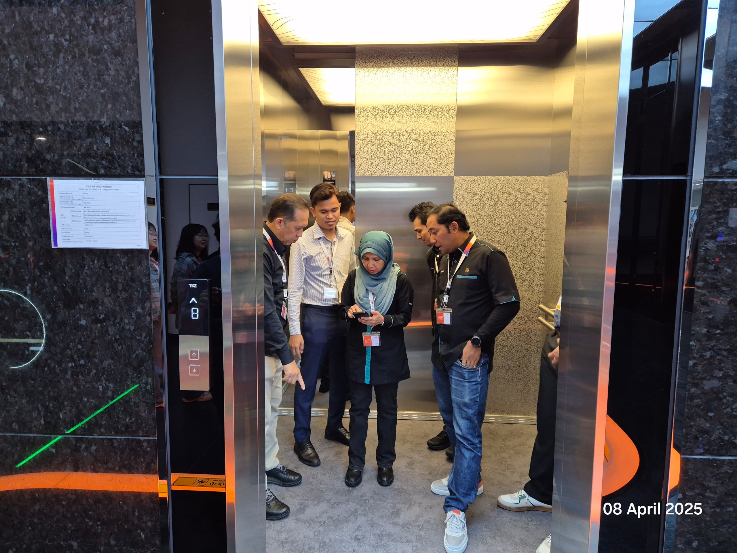 The group standing inside a luxury sample cabin with patterned metal walls, marble panels and LED lighting