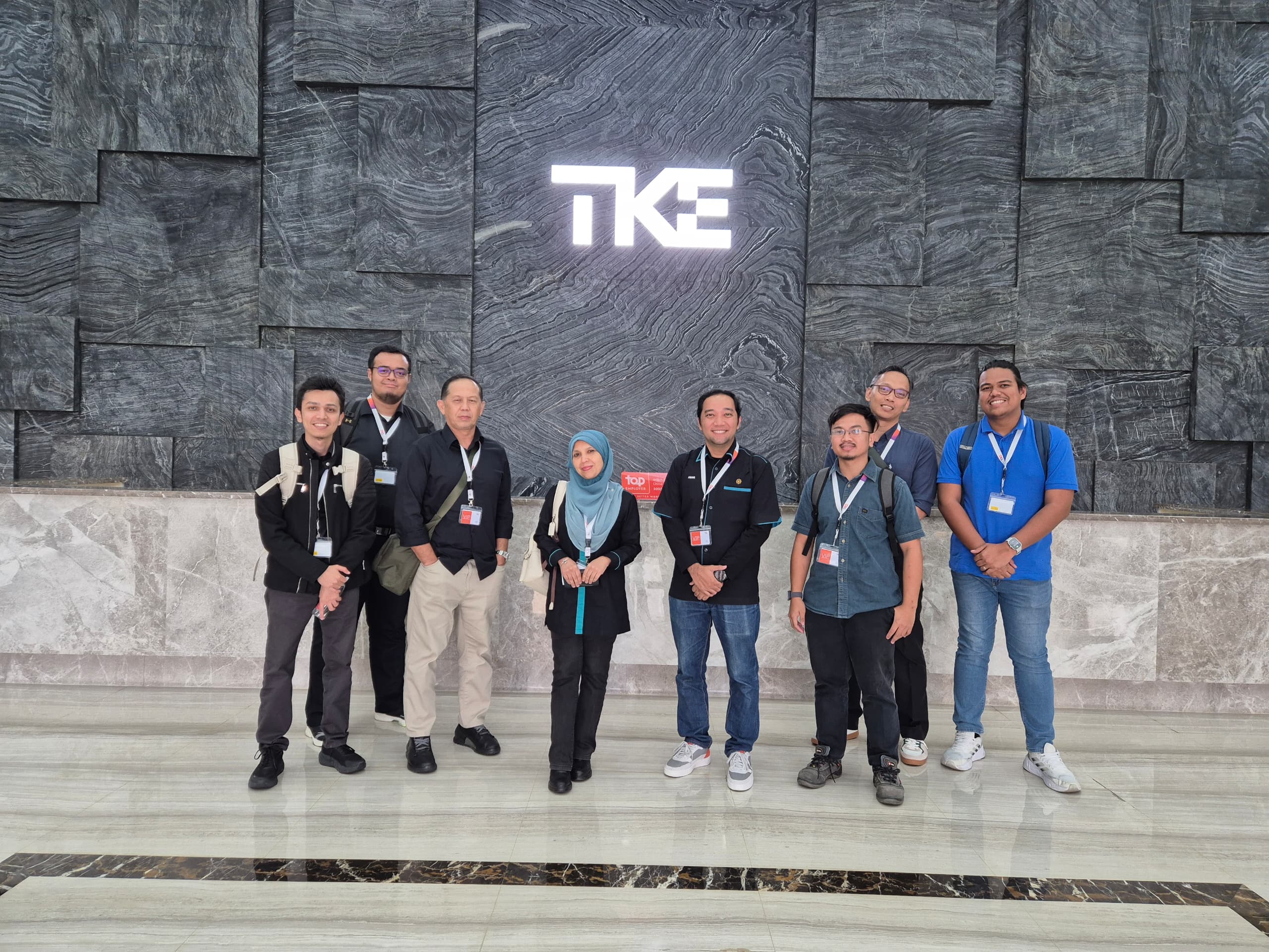 Our group standing in front of the illuminated TKE logo at the Zhongshan facility
